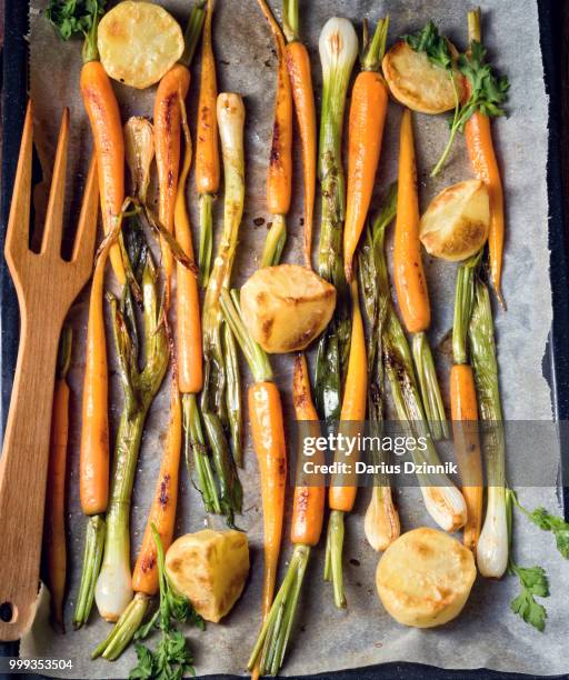 caramelised carrots, spring onions and baked potatoes - carotine stock-fotos und bilder