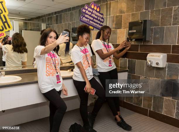 Guests take bathroom selfies in front of stickers featuring Bathroom Mirror Lyrics during HBO's Mixtapes & Roller Skates at the Houston Funplex on...