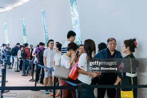People wait in line outside the sales office for the Victoria Harbour residential project, developed by Sun Hung Kai Properties Ltd., in Hong Kong,...