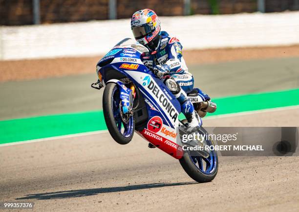 Spanish Honda rider Jorge Martin pulls a wheelie after winning the Moto3 race at the Grand Prix of Germany at the Sachsenring Circuit on July 15,...