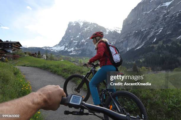 pov to woman on ebike in mountains - extreme sports point of view stock pictures, royalty-free photos & images