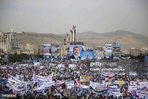 Supporters of Yemen's former president Ali Abdullah Saleh carry his pictures during the 35th anniversary celebration of his General People's Congress...