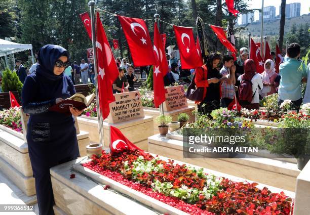 Woman prays next a tomb as people visit graves of their relatives who died during the failed coup on July 15, 2016 in Turkey, during a ceremony...
