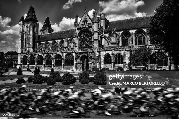 The pack rides past the Notre-Dame des Andelys church, in Les Andelys, during the eighth stage of the 105th edition of the Tour de France cycling...