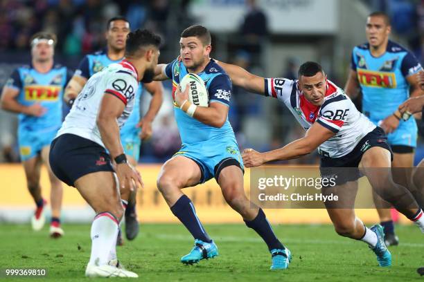 Ash Taylor of the Titans is tackled during the round 18 NRL match between the Gold Coast Titans and the Sydney Roosters at Cbus Super Stadium on July...