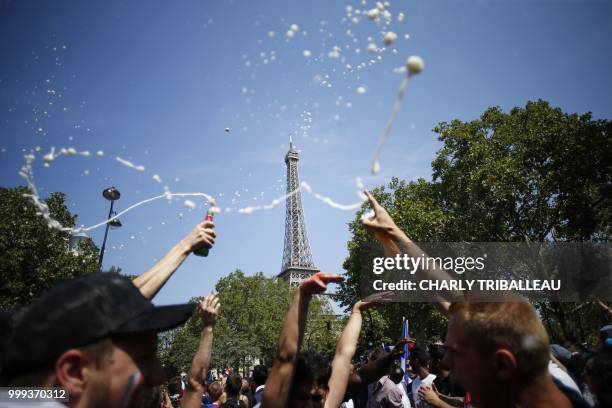 Supporters of France's national football team gather near the Fanzone at the Champ de Mars in front of the Eiffel Tower in Paris on July 14, 2018 a...