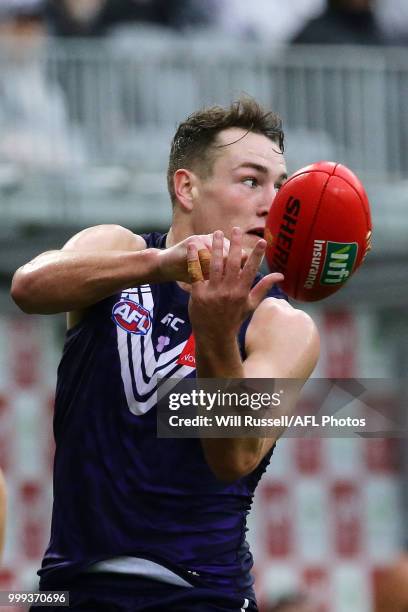 Brennan Cox of the Dockers handpasses the ball during the round 17 AFL match between the Fremantle Dockers and the Port Adelaide Power at Optus...