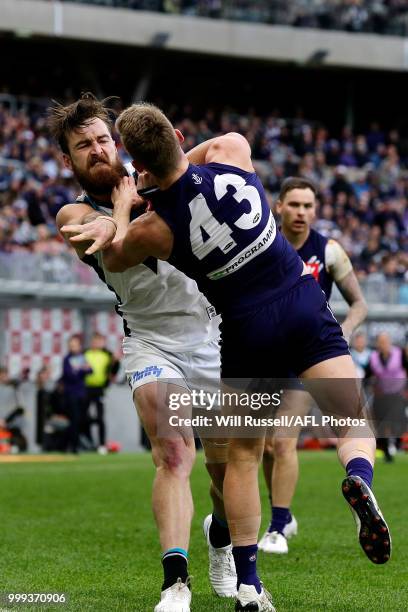 Ryan Nyhuis of the Dockers is pushed by Charlie Dixon of the Power after the tackle on Robbie Gray of the Power during the round 17 AFL match between...