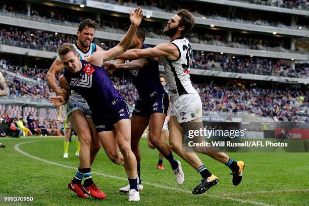 Ryan Nyhuis of the Dockers is pushed by Justin Westhoff of the Power after the tackle on Robbie Gray of the Power during the round 17 AFL match...