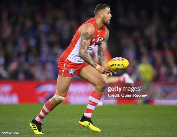 Lance Franklin of the Swans handballs during the round 17 AFL match between the North Melbourne Kangaroos and the Sydney Swans at Etihad Stadium on...