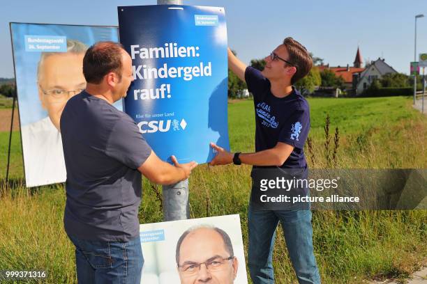 Markus Diessl , Zeugendorf municipal councilor, and Andre Kraus Seukendorf municipal councilor, putting up an electoral campaign poster of the CSU in...