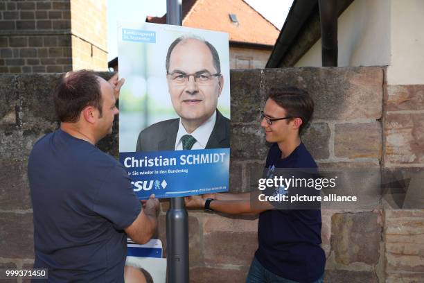 Markus Diessl , Zeugendorf municipal councilor, and Andre Kraus Seukendorf municipal councilor, putting up an electoral campaign poster of the CSU in...