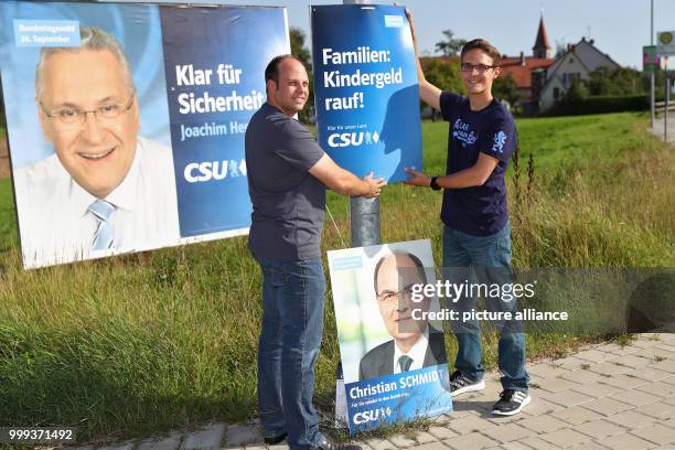 Markus Diessl , Zeugendorf municipal councilor, and Andre Kraus Seukendorf municipal councilor, putting up an electoral campaign poster of the CSU in...