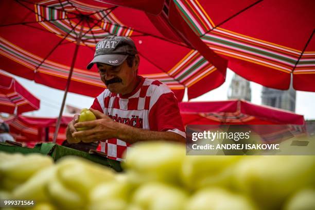 Man wearing a tee-shirt with Croatian national colours arranges paprika at a market in downtown Zagreb on July 15 ahead of the 2018 Russia World Cup...