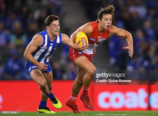 Oliver Florent of the Swans is tackled by Nathan Hrovat of the Kangaroos during the round 17 AFL match between the North Melbourne Kangaroos and the...