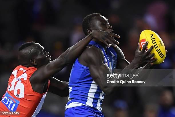 Majak Daw of the Kangaroos marks infront of Aliir Aliir of the Swans during the round 17 AFL match between the North Melbourne Kangaroos and the...