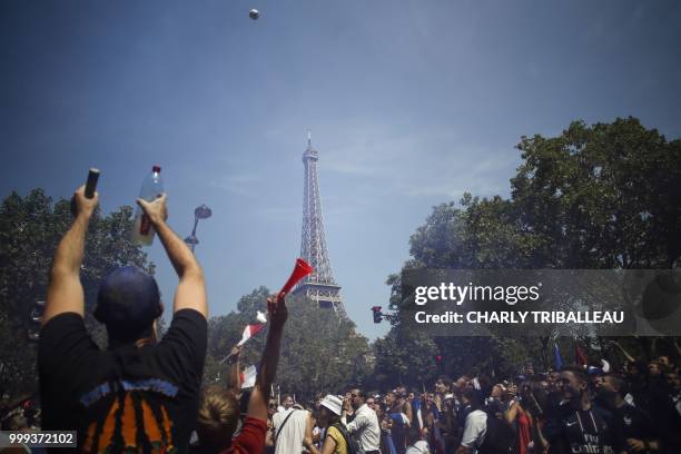 Supporters of France's national football team gather near the fan zone at the Champ de Mars, in front of the Eiffel Tower in Paris on July 15, 2018 a...