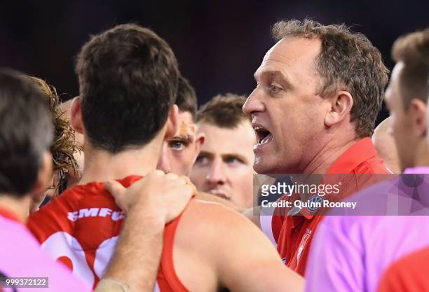 Swans head coach John Longmire talks to his players during the round 17 AFL match between the North Melbourne Kangaroos and the Sydney Swans at...