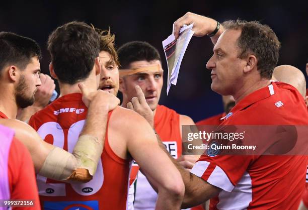 Swans head coach John Longmire talks to his players during the round 17 AFL match between the North Melbourne Kangaroos and the Sydney Swans at...