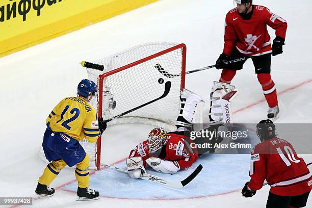 Fredrik Pettersson of Sweden scores his team's fourth goal against goalkeeper Tobias Stephan, Timo Helbling and Andreas Ambuhl of Switzerland during...