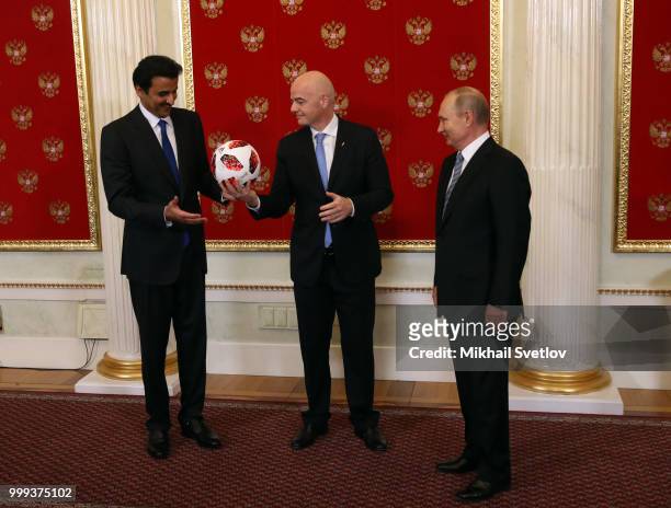 Russian President Vladimir Putin passes symbolic FIFA World Cup Baton to Qatari Emir Tamim bin Hamad al-Thani as FIFA President Gianni Infantino...