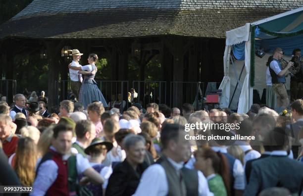 Dpatop - 15 July 2018, Germany, Munich: People dancing, guided by the couple on stage, at the Kocherlball by the Chinesischer Turm . Every year,...