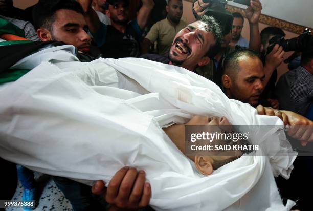 Graphic content / A man reacts as relatives and mourners carry the body of 15-year-old Palestinian Amir al-Namira, who was killed the day before in...