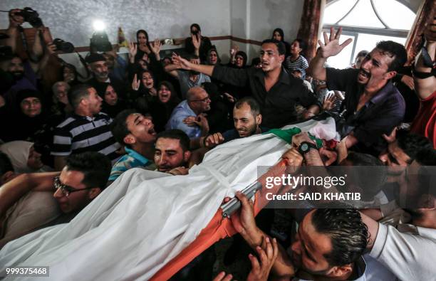 Graphic content / Relatives and mourners carry the body of 15-year-old Palestinian Amir al-Namira, who was killed the day before in an Israeli air...