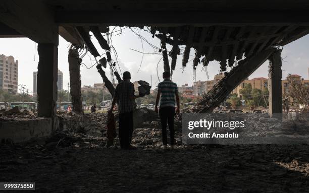 Palestinians inspect damaged building after Israeli fighter jets pounded Al Katiba region in Gaza City, Gaza on July 15, 2018.