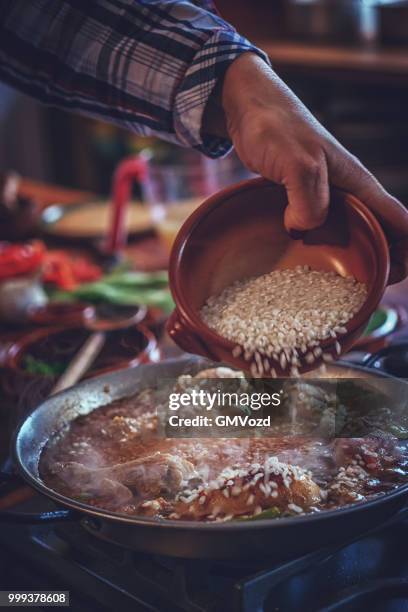preparing chicken paella with green beans, peas and paprika - gmvozd stock pictures, royalty-free photos & images