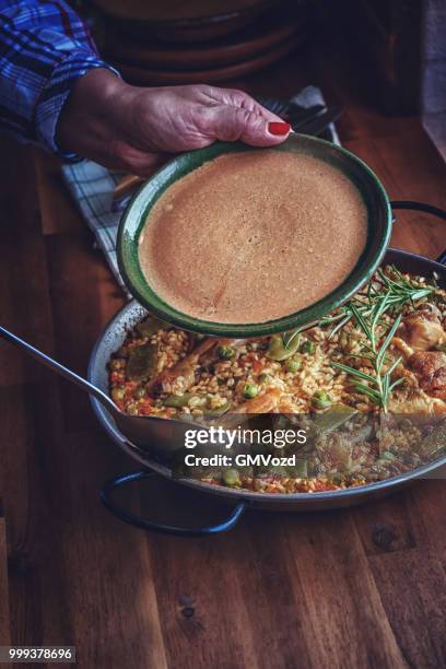 preparing chicken paella with green beans, peas and paprika - gmvozd stock pictures, royalty-free photos & images