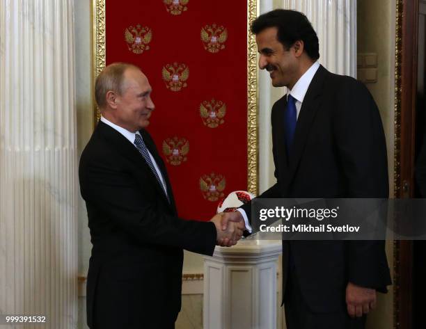 Russian President Vladimir Putin shakes hands with Qatari Emir Tamim bin Hamad al-Thani during their meeting at the Kremlin, in Moscow, Russia, July...