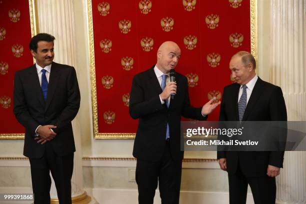 Russian President Vladimir Putin looks on s Qatari Emir Tamim bin Hamad al-Thani and FIFA President Gianni Infantino during the ceremony at the...