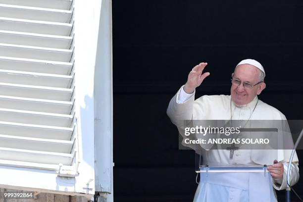 Pope Francis waves to the crowd from the window of the apostolic palace overlooking St Peter's square during the Sunday Angelus prayer, on July 15,...