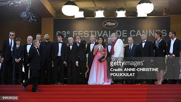 French director Xavier Beauvois points as he arrive with his cast for the screening of "Des Hommes et des Dieux" presented in competition at the 63rd...