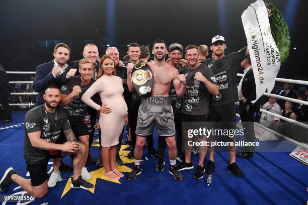 July 2018, Germany, Offenburg: Boxing: WBA super middleweight title fight. Rocky Fielding of Britain celebrates with his team after his win over...