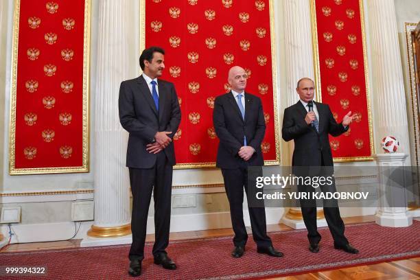 Russian President Vladimir Putin delivers a speech as FIFA President Gianni Infantino and Emir of Qatar Sheikh Tamim bin Hamad Al-Thani looks on...