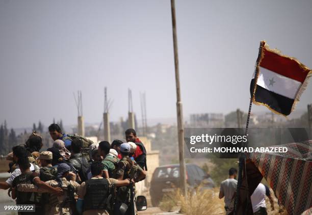 Syrian rebels pass by a regime checkpoint during evacuation from Daraa city, on July 15 as Syrian government forces heavily bombed the neighbouring...