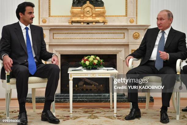 Emir of Qatar Sheikh Tamim bin Hamad Al-Thani speaks with Russian President Vladimir Putin during their meeting at the Kremlin in Moscow on July 15,...