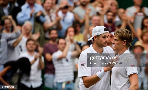 Kevin Anderson of South Africa commiserates with John Isner of the United States after beating him in the semi final of the gentlemen's singles at...