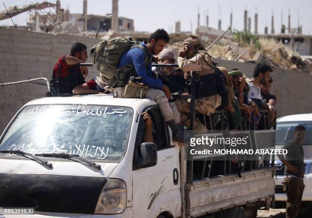 Syrian rebels ride on a truck during evacuation from Daraa city, on July 15 as Syrian government forces heavily bombed the neighbouring province of...