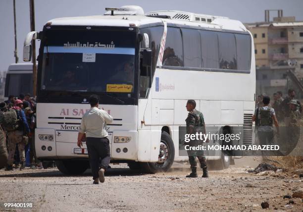 Syrian rebels ride on buses during evacuation from Daraa city, on July 15 as Syrian government forces heavily bombed the neighbouring province of...