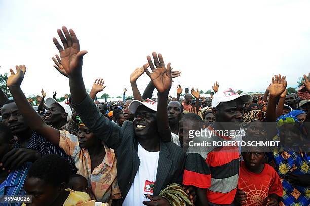 Burundi's Nkurunziza on God and grassroots development** Supporters of Burundian President Pierre Nkurunziza wave as they watch him leave a political...