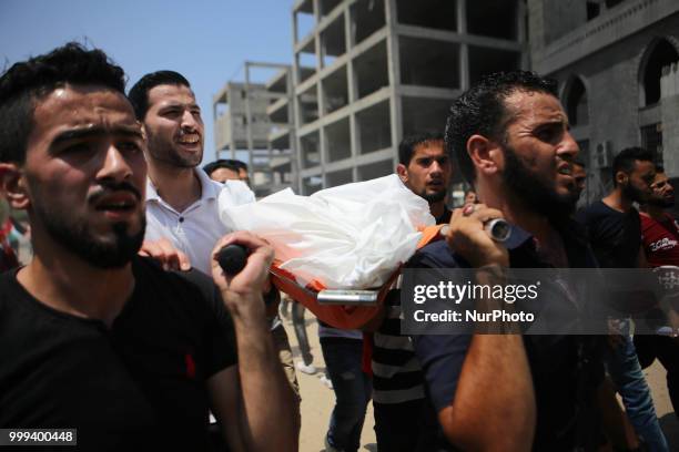 Relatives and mourners carry the body of 15-year-old Palestinian Amir al-Namira, who was killed the day before in an Israeli air strike, during his...