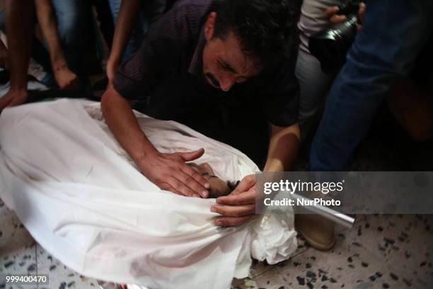 Relatives and mourners carry the body of 15-year-old Palestinian Amir al-Namira, who was killed the day before in an Israeli air strike, during his...