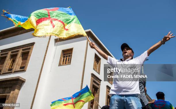 Moroccan demonstrator shouts slogans while waving the Berber, or Amazigh, flag during a protest against the jailing of Al-Hirak al-Shaabi or "Popular...