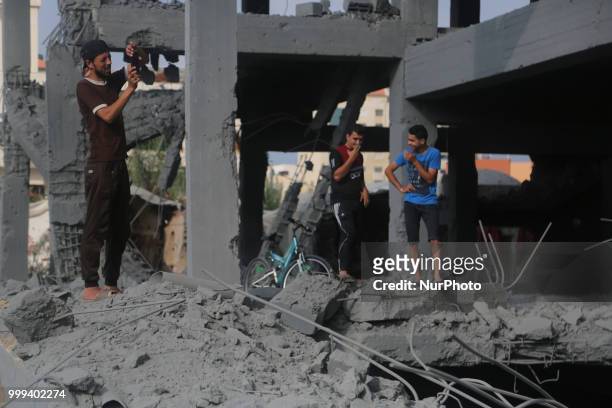 Palestinians walk through the wreckage of a building that was damaged by Israeli air strikes in Gaza City on July 15, 2018. Israel's military said it...