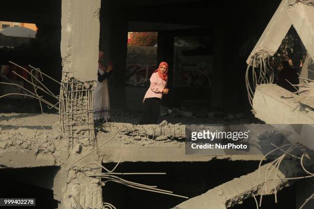 Palestinians walk through the wreckage of a building that was damaged by Israeli air strikes in Gaza City on July 15, 2018. Israel's military said it...