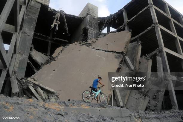 Palestinians walk through the wreckage of a building that was damaged by Israeli air strikes in Gaza City on July 15, 2018. Israel's military said it...