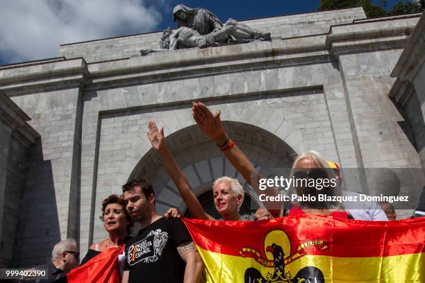 Far right-wing supporters do fascist salutes as they hold a pre-constitutional Spanish flag during a gathering at El Valle de los Caidos under the...